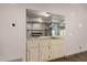 Built-in wet bar with mirrored backsplash and wood cabinets at 10473 N 87Th Pl, Scottsdale, AZ 85258