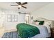 Main bedroom with green velvet comforter and barn door to en-suite bathroom at 10529 W Palmeras Dr, Sun City, AZ 85373