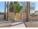 Aztec Court community entrance with brick walls and mature palm trees at 10529 W Palmeras Dr, Sun City, AZ 85373