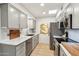 Modern galley kitchen, featuring gray cabinets, marble countertops, and stainless steel appliances at 10529 W Palmeras Dr, Sun City, AZ 85373