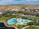 Aerial view of community pool, clubhouse, and surrounding landscape at 10724 S Mustang Dr, Goodyear, AZ 85338