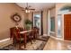 A formal dining room with a wood table and chairs, tile floors, and large windows at 10724 S Mustang Dr, Goodyear, AZ 85338