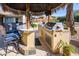 Outdoor kitchen with built-in grill and bar seating at 10724 S Mustang Dr, Goodyear, AZ 85338