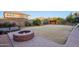 Large backyard with fire pit, shed, and grassy area at 1132 W Santa Gertrudis Trl, San Tan Valley, AZ 85143