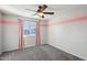 Bedroom with pink accent wall, ceiling fan, and gray carpet at 1132 W Santa Gertrudis Trl, San Tan Valley, AZ 85143