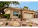 Tan stucco house with tile roof, desert landscaping, and a two-car garage at 11664 E Caron St, Scottsdale, AZ 85259