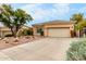 Tan stucco house with tile roof, desert landscaping, and a two-car garage at 11664 E Caron St, Scottsdale, AZ 85259