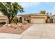 Tan stucco house with tile roof, desert landscaping, and a two-car garage at 11664 E Caron St, Scottsdale, AZ 85259