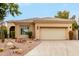 Tan stucco house with tile roof, desert landscaping, and a two-car garage at 11664 E Caron St, Scottsdale, AZ 85259