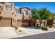 Tan two-story townhome with two-car garage and desert landscaping at 11683 N 135Th Pl, Scottsdale, AZ 85259