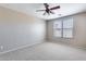 Spacious bedroom with window, ceiling fan, and carpet at 11820 W Monte Lindo Ln, Sun City, AZ 85373