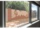 View of backyard through kitchen window; features a painted brick wall at 11860 W Grant St, Avondale, AZ 85323