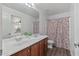 Bathroom with double vanity, shower/tub, and floral curtain at 11860 W Grant St, Avondale, AZ 85323