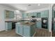 Kitchen with teal cabinets, island, and stainless steel appliances at 11860 W Grant St, Avondale, AZ 85323