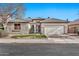 Single-story home with neutral exterior, two-car garage, and well-manicured lawn at 11930 W Monroe St, Avondale, AZ 85323