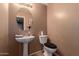 Clean bathroom with pedestal sink and updated toilet at 12305 W Flores Dr, El Mirage, AZ 85335