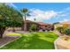 Landscaped backyard featuring a putting green, patio, and citrus tree at 13438 W Ashwood Dr, Sun City West, AZ 85375