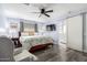 Main bedroom with ceiling fan, large bed, and barn door to en-suite bathroom at 13438 W Ashwood Dr, Sun City West, AZ 85375