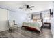 Main bedroom with ceiling fan, large bed, and barn door to en-suite bathroom at 13438 W Ashwood Dr, Sun City West, AZ 85375