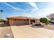 Tan single story house with a two-car garage and landscaped yard at 13438 W Ashwood Dr, Sun City West, AZ 85375