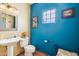 Small bathroom with pedestal sink, toilet, and blue walls at 17203 E Calaveras Ave, Fountain Hills, AZ 85268