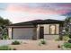 One-story home with gray siding, stone accents, and a two-car garage at 18228 W Daley Ln, Surprise, AZ 85387