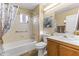 Bathroom with tub, shower, wood vanity, and window at 19806 N Stardust Blvd, Sun City West, AZ 85375