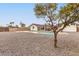 Backyard with gravel, a tree, and a view of the pool and house at 2407 E Encanto St, Mesa, AZ 85213