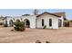 White house with a dark brown garage door and shrubs at 2407 E Encanto St, Mesa, AZ 85213