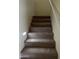 Carpeted staircase with a modern light fixture at 2431 N 83Rd Dr, Phoenix, AZ 85037