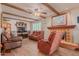 Cozy living room features leather furniture, a fireplace, and wood beams at 250 E Voltaire Ave, Phoenix, AZ 85022