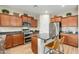 Kitchen with granite countertops, wooden cabinets, and a breakfast bar at 25719 N 54Th Dr, Phoenix, AZ 85083