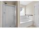 Well lit bathroom featuring a bathtub and stand up shower with glass door at 29061 N Cactus Cir, San Tan Valley, AZ 85143