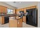 Kitchen with wood cabinets, black appliances, and a kitchen island at 29061 N Cactus Cir, San Tan Valley, AZ 85143