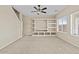 Living room featuring built-in shelving unit, carpeted floors, and a ceiling fan at 29061 N Cactus Cir, San Tan Valley, AZ 85143