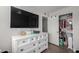 Bedroom with white dresser, closet, and large TV at 3808 W Mission Ln, Phoenix, AZ 85051