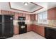 Kitchen with dark wood cabinets, granite counters and black appliances at 4538 W Sierra St, Glendale, AZ 85304