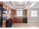 Kitchen with dark wood cabinets, granite counters and black appliances at 4538 W Sierra St, Glendale, AZ 85304