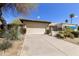 View of the home's garage and driveway, showcasing desert landscaping and a gated entrance at 4602 E Monte Way, Phoenix, AZ 85044