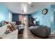 Living room with light beige couch, gray beanbag chair, and blue walls at 521 W Jardin Loop, Casa Grande, AZ 85122