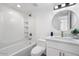 Modern bathroom with white vanity, round mirror, and bathtub at 5238 N 42Nd Ln, Phoenix, AZ 85019