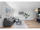 Bright living room with gray sectional sofa, coffee table, and wood floors at 5238 N 42Nd Ln, Phoenix, AZ 85019