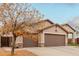 Tan two-car garage home with decorative sun design and autumn leaves at 5711 W Lydia Ln, Laveen, AZ 85339