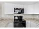 Modern kitchen features black stovetop and microwave, and white cabinets at 604 W Emerald Ave, Mesa, AZ 85210