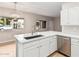 Modern kitchen with white cabinets, stainless steel sink, and a view to the outside at 6920 E 4Th St # 103, Scottsdale, AZ 85251