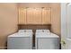 Bright laundry room with upper cabinets and Samsung washer and dryer at 6931 W Blackhawk Dr, Glendale, AZ 85308