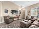 Bright living room featuring comfortable seating and a large TV at 6931 W Blackhawk Dr, Glendale, AZ 85308