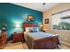 Bright bedroom with teal accent wall and wooden bed frame at 8429 W Sands Ct, Peoria, AZ 85383