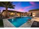 Evening view of a beautiful pool, spa, and outdoor entertainment area at 8429 W Sands Ct, Peoria, AZ 85383