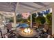 Fire pit and seating area under a pergola, adjacent to the pool at 15891 W Avalon Dr, Goodyear, AZ 85395